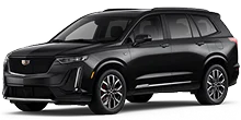 A black Cadillac XT6 luxury SUV is shown in a three-quarter frontal view against a plain, light beige background.